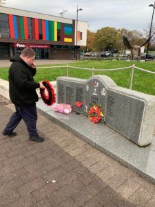 Picture of student laying poppies down on the war memorial