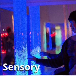 a student in the sensory pod, using a bubble tube